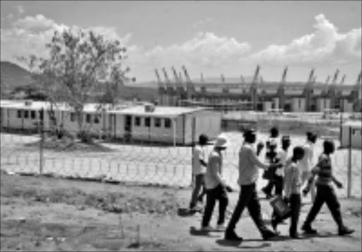 Deserted: Cyril Clarke High School pupils walk past their temporary learning shelters next to Mbombela stadium near Nelspruit in Mpumalanga yesterday. Pic: Andrwe Hlongwane. Circa 2009. © Sowetan.