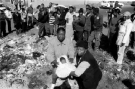 NO CHANCE: Thembi da Silva, left, holds a newborn baby which was found on a rubbish site in the Vaal. The baby died later. Pic. Len Kumalo. 08/07/08. © Sowetan.