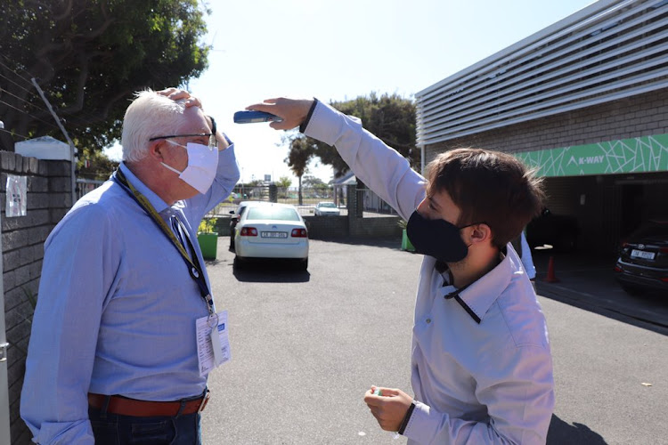 Western Cape Premier Alan Winde is screened before entering a K-Way factory that has been turned over to making masks for the Covid-19 pandemic.