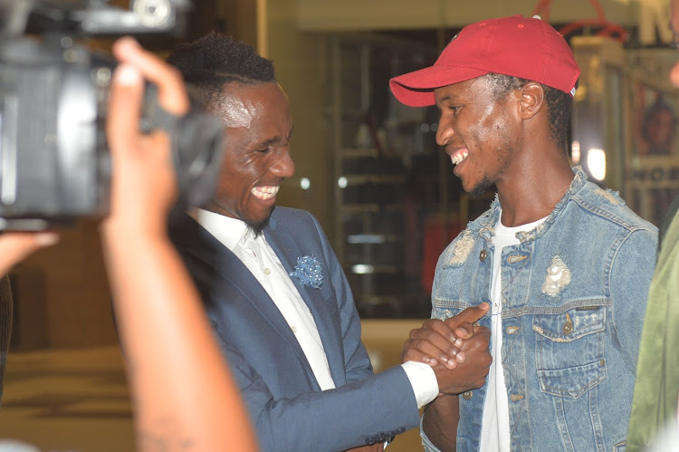 Former Mamelodi Sundowns teammates Teko Modise (L) share a fun moment with Themba Zwane (R) during the launch of the former's book in November 2017.