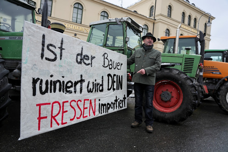 Bavarian Economic Minister Hubert Aiwanger stands next to a banner that reads "if the farmer is ruined, your food will be imported", as German farmers take part in a protest against the cut of vehicle tax subsidies of the so-called German Ampel coalition government, in Munich. Picture: LEO SIMON