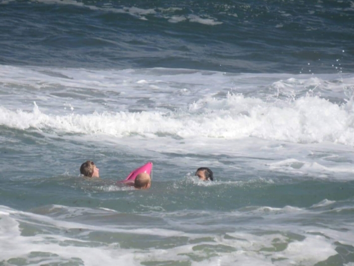 Thea Fox Marx rescues two unidentified people at Glentana beach using one of the NSRI's pink rescue buoys.