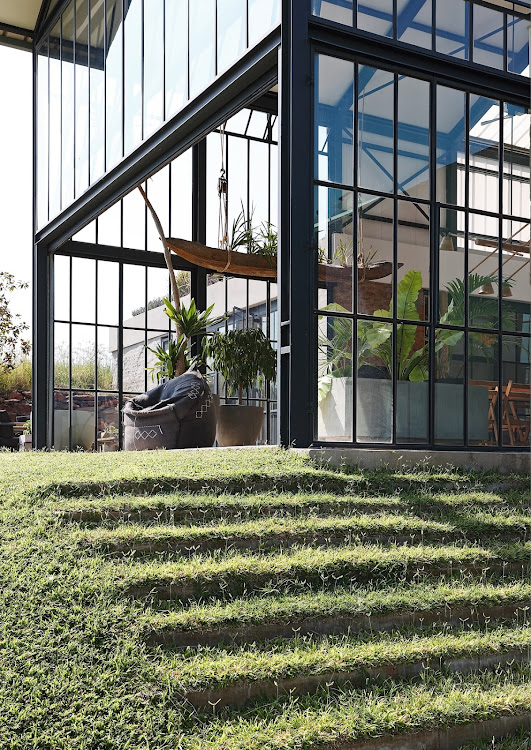 A grassy staircase has been carved into the incline, in which parts of the house are submersed.