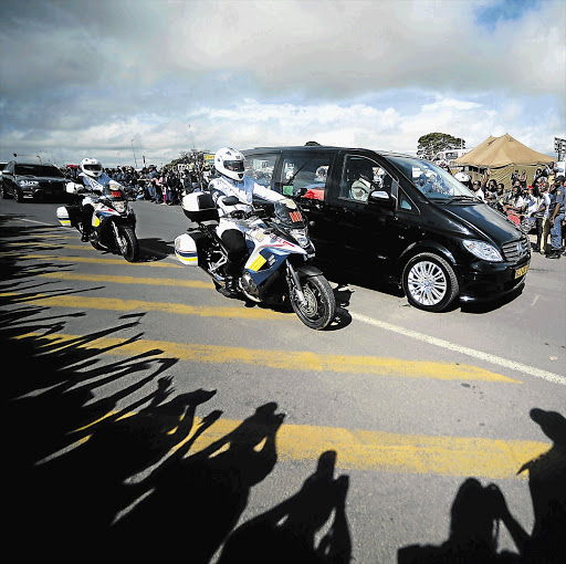 The hearse carrying the coffin of Nelson Mandela drives through Mthatha yesterday on its way to Qunu, where he will be buried today. Thousands of people lined the streets of the city to catch a glimpse of the funeral cortège Picture: AFP