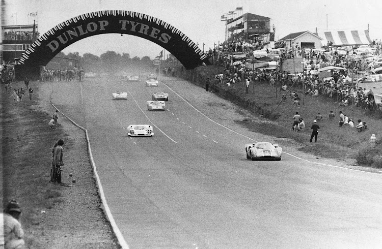 Sports cars roar down the long main straight of the original circuit.