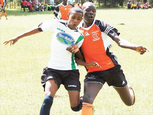 Anzara Shamun of St. Athony (left) vies for the ball with Jok Mach of Menengai in Eldoret on Tuesday. /STANLEY MAGUT
