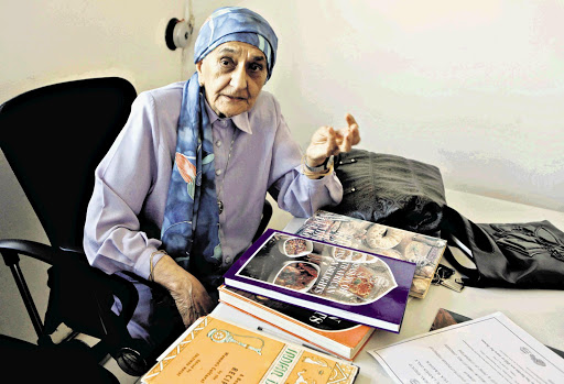 Zuleika Mayat with the various editions of her cookbook
