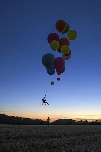 Tom Morgan flew 25km in a camping chair attached to a host of helium balloons.