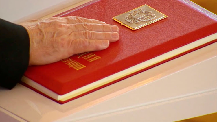 Russian President Vladimir Putin places his hand on the Constitution as he takes the oath during an inauguration ceremony at the Kremlin in Moscow, Russia, on May 7 2024, in this still image taken from live broadcast video.