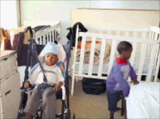 LOVING CARE: Volunteers do their best for these two little children and 26 others. © Sowetan.