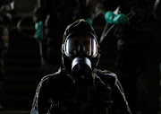 An airforce member is seen with a full cover mask as he sprays disinfectant inside a main railway station, as the number of people tested positive for Covid-19 in the country increased, in Colombo, Sri Lanka, on March 18 2020. 