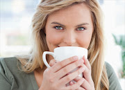Woman with beautiful eyes drinking a cup of coffee or tea
