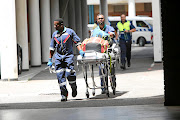 Medics leave the scene of a  shooting in the Durban regional court where two people were killed  in a divorce case. /JACKIE CLAUSEN
