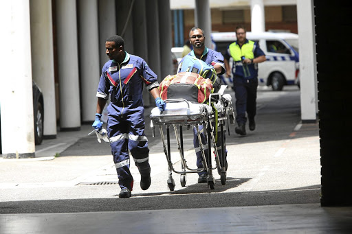 Medics leave the scene of a shooting in the Durban regional court where two people were killed in a divorce case. /JACKIE CLAUSEN