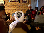 Zainab Bassa (red scarf) wife of Malmesbury mosque victim Ismail Bassa, 74, during prayers at her home on June 14 2018.