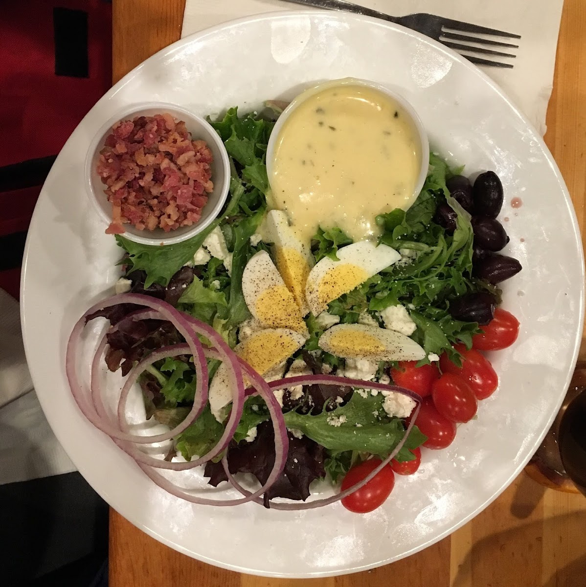Gustav’s Salad: Greens with tomato, olives, bacon, red onion, blue cheese crumbles  and egg with Honey Mustard Dressing.