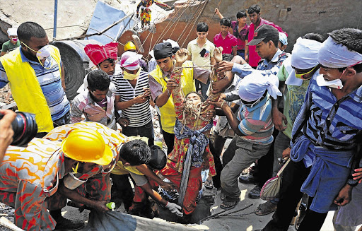 Rescue workers pull a garment worker from the rubble of the Rana Plaza, near Dhaka, Bangladesh. Survivors described a deafening bang and tremors before the building crashed down under them