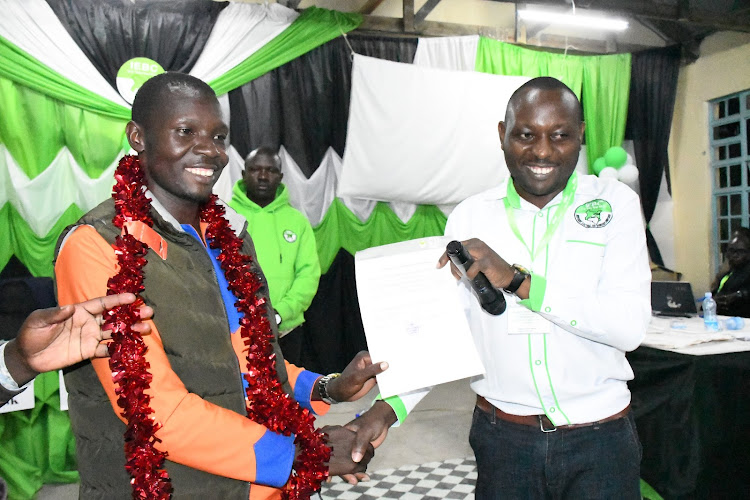 Ronald Ochalu who won in Malaba Central ward receives his certificate from Teso North IEBC chief Andrew Wetende on August 11, 2022 at St. Thomas Amagoro Girls High School in Teso North.