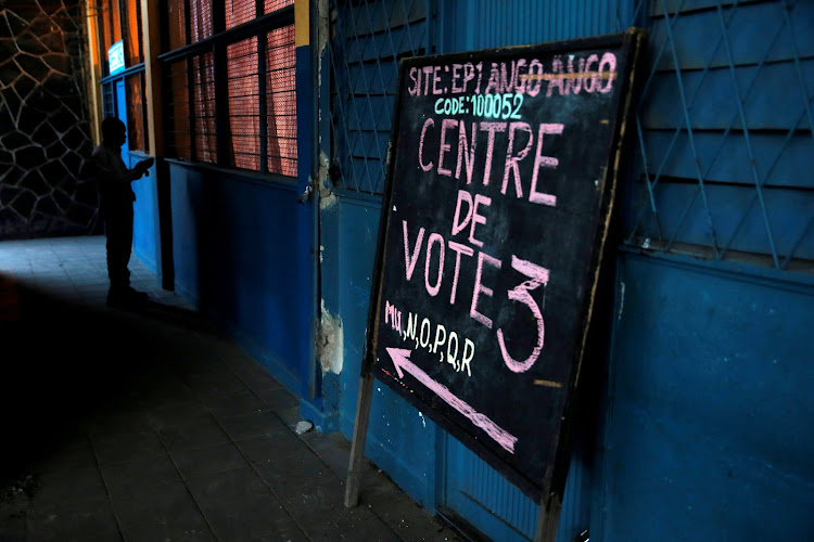 A man is seen next to a sign pointing to polling station in Kinshasa, Democratic Republic of Congo, December 29 2018.
