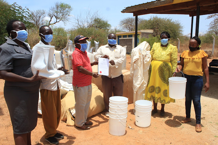NGOMENI BEEKEEPERS COOPERATIVE REPRESENTATIVES RECEIVING A CERTIFICATE AND BEE HARVESTING EQUIPMENT