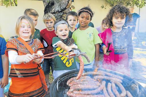 BRAAI DAY FEVER: Skye-Mari Perkins, Gary Driffield, Mbali Ncunyana and Kayden Mauer enjoy a braai in traditional clothing as they celebrated Heritage Day at Peter Pan Nursery School in Stirling yesterday Picture: STEPHANIE LLOYD