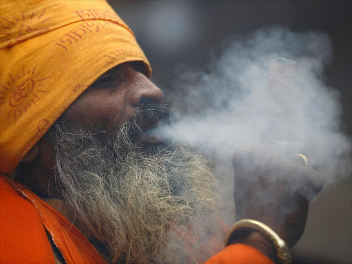 A Hindu holy man, or sadhu, smokes marijuana in a chillum on the premises of Pashupatinath Temple in Kathmandu February 17, 2015. /REUTERS