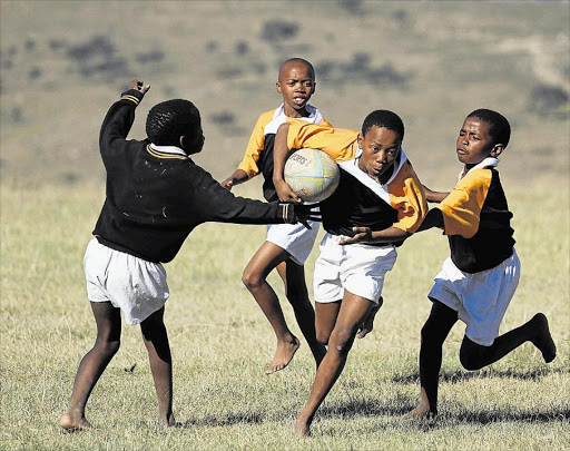 POSITIVE IMPACT: Aphelele Dayinane from Thembalethu Higher and Lower Primary School runs with the ball during a fun game of rugby Picture: ALAN EASON