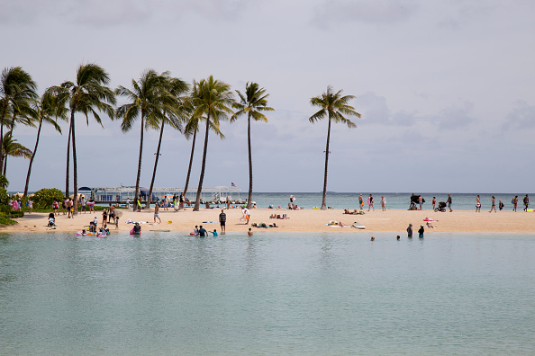 Tourists enjoy a gorgeous day at the beach in Waikiki, Hawaii.