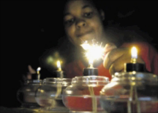 Itumeleng Tsotetsi waitron at the Spur in Moponya Mall lighting canddles after power failer .Pic Elizabeth Sejake 17/01/2008