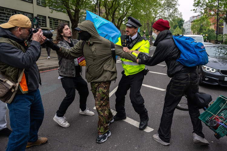 A police officer tries to detain a protester at a hotel in Peckham, London, England, on May 2 2024. The UK government has set about detaining migrants and deporting them to Rwanda after passing the Rwanda Bill. Picture: CARL COURT/GETTY IMAGES