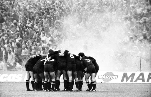 The All Black team goes into a huddle after anti-apartheid protesters in a light aircraft dropped flour bombs on the Eden Park pitch during the last test of the Springboks’ 1981 rugby tour.