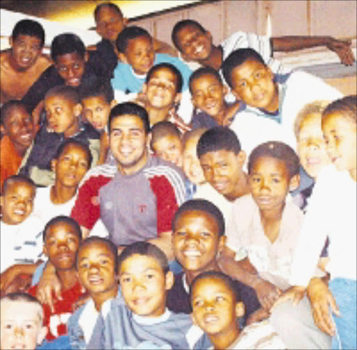 TOMORROW'S CHAMPS: Amro Hassen, an Egyptian national wrestling champion, surrounded by his young team from the Welkom Wrestling Club. Pic. Victor Mecoamere. © Sowetan.