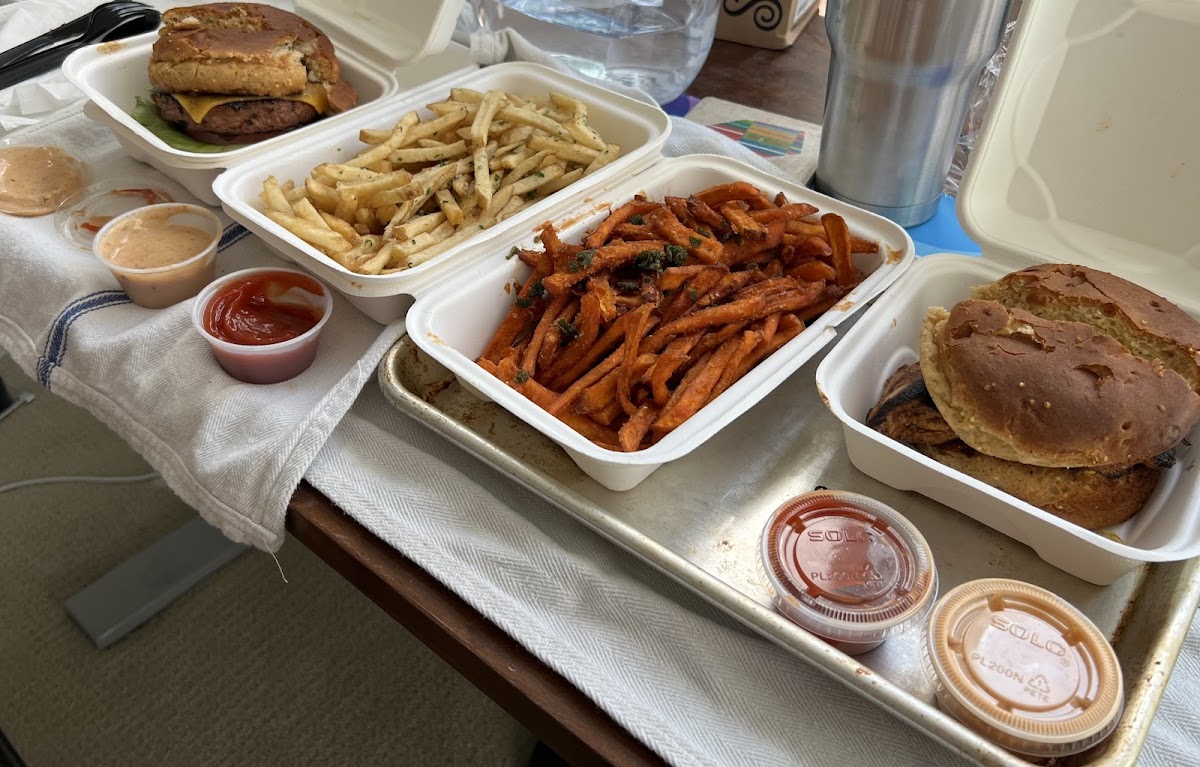 Takeout with two burgers, two fries, and sauces