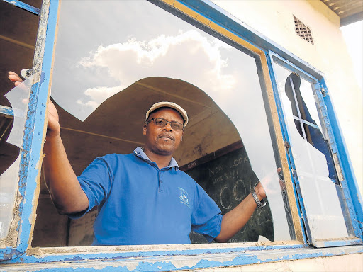 PUPIL FRENZY: Zamukulungisa Junior Secondary School deputy principal Lonwabo Sijaji shows one of the broken windows after a fight involving pupils at the school Picture: LOYISO MPALANTSHANE