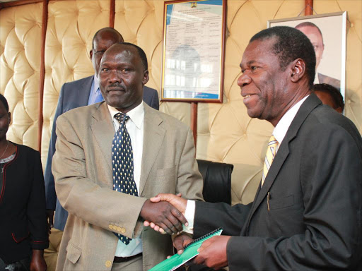 Health PS Fred Segor hands over a performance contract document to Kenya Medical Training College chairperson Joe Donde in Afya House, Nairobi, on September 19, 2013 /CHARLES MUGA