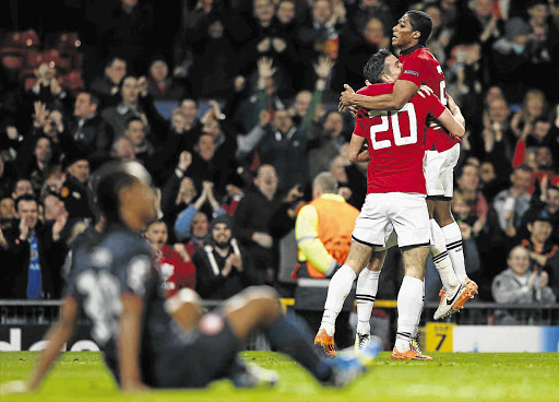 THANKS, MATE: Manchester United's Antonio Valencia, right, and Robin van Persie celebrate a second goal against Olympiakos during their Uefa Champions League last-16 round match at Old Trafford last night