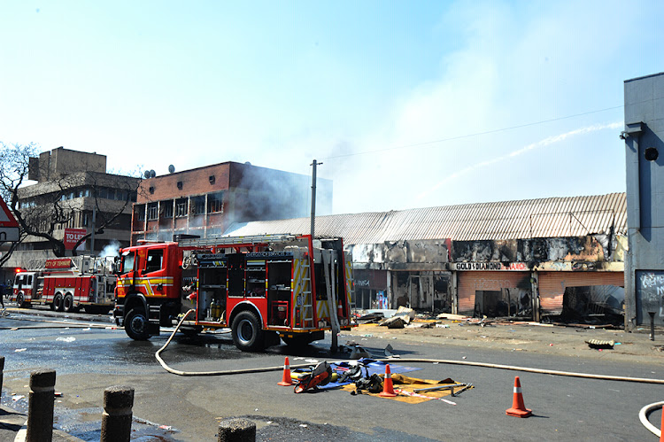 Fire fighters extinguish fires in Pretoria after protests on August 28 2019.