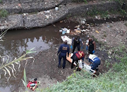 Police Search and Rescue divers recover the body of a boy who drowned while swimming in a stream in Phoenix at the weekend.