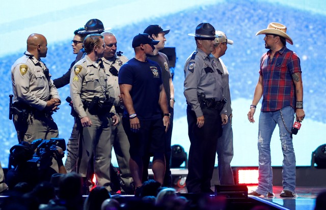Jason Aldean (R) and radio personality Bobbie Bones honor first responders of the Oct 1, 2017 Las Vegas mass shooting during the iHeartRadio Music Festival at T-Mobile Arena in Las Vegas, Nevada, US, September 21, 2018.