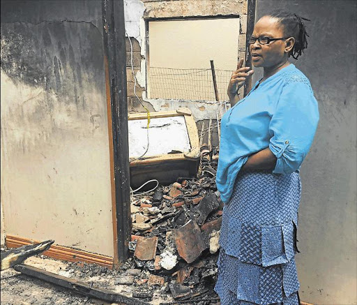 DEVASTATED: Widowed 53-year-old Yekelwa Ntsabo looks at the burn-out shell that was her family’s home for the past 19 years. Police are investigating a case of arson Picture: MAMELA GOWA