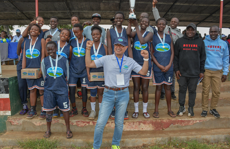 Brookside's marketing director, Reza Chabokro (front) celebrates with national handball champions Butere Girls at Machakos Boys on Saturday.