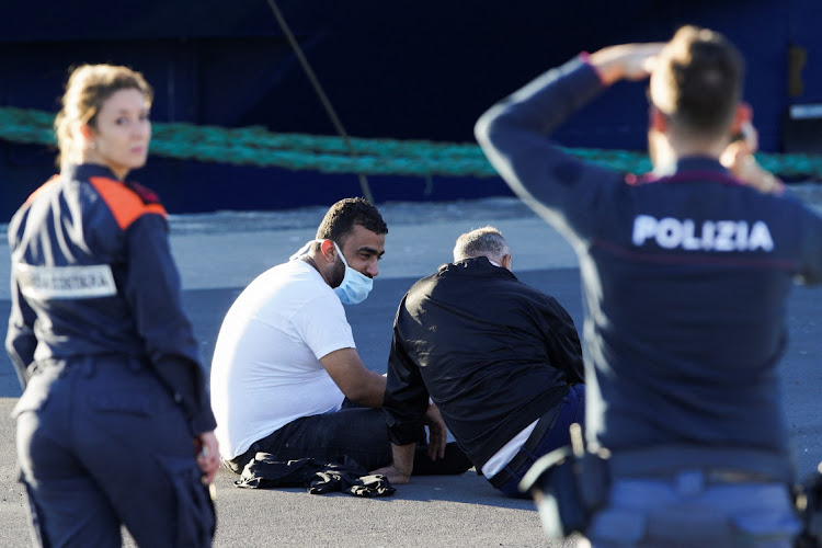 Italian port guards watch migrants who protested at the Italian government's decision not to let them disembark, in the port of Catania, Italy, November 7 2022. Picture: ANTONIO PARRINELLO/REUTERS