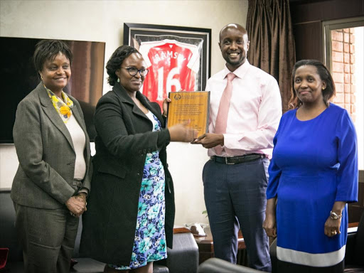 Sportpesa CEO Ronald Karuri receives award from KRA's Emma Mwambia on March 15, 2018./COURTESY