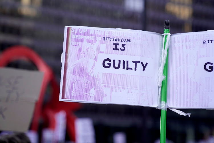 A demonstrator holds a placard during a protest in the wake of Kyle Rittenhouse's "not guilty" verdict in a Kenosha courtroom, in Chicago, Illinois, US November 20, 2021.