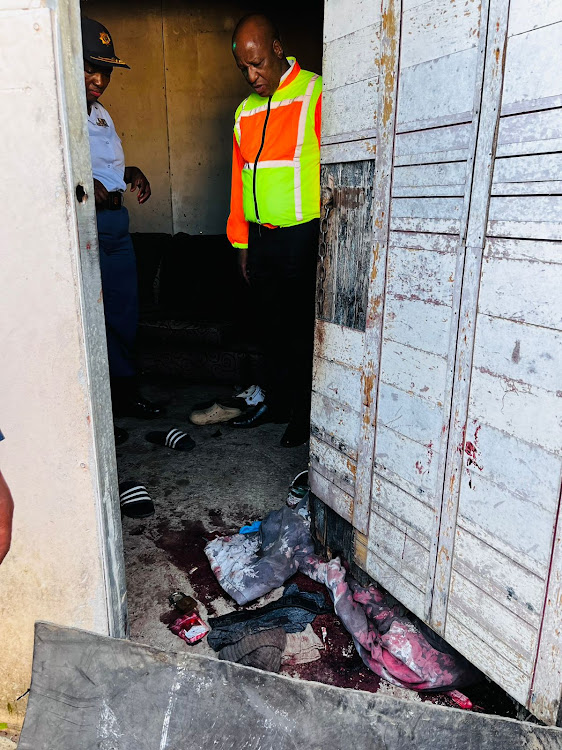 Premier Thami Ntuli at the scene of the incident, with blood still visible at the door