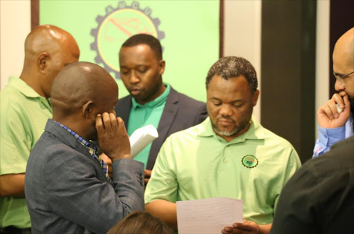 #AMCU leadership and mining company representatives looking over the wage agreements & other conditions of employment.