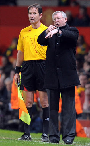 Manchester United manager Sir Alex Ferguson points to his watch during the UEFA Champions League second leg quarter-final football match Manchester United vs FC Bayern Munich at Old Trafford in Manchester, north-west England, on April 7, 2010.Ferguson has revealed that he would only point at his watch to play on the minds of match officials and opponents despite rarely being aware of how many minutes were left in a match for his Manchester United side to find a goal. AFP PHOTO / ANDREW YATES