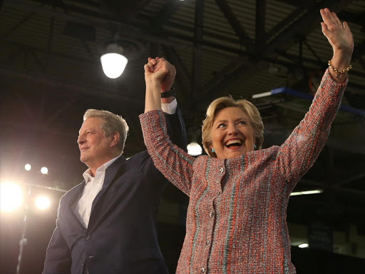 US Democratic presidential nominee Hillary Clinton (R) and former Vice President Al Gore shake hands after talking about climate change at a rally at Miami Dade College in Miami, Florida, US October 11, 2016. /REUTERS