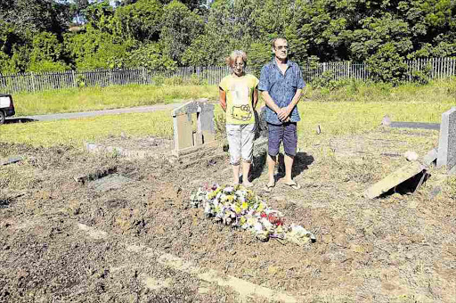 TRAUMATISED: Eddelina Hall and her brother Marthinus Deysel at their mother’s grave, which was left open and had been flooded Picture: SINO MAJANGAZA