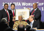 The South African delegation of Irvin Khoza, Danny Jordaan and Nelson Mandela, with Fifa president Sepp Blatter and Molefi Oliphant showing the name of South Africa at the announcement that the country would host the 2010 Soccer World Cup, during an official ceremony in Zurich, Switzerland, on May 15 2004.